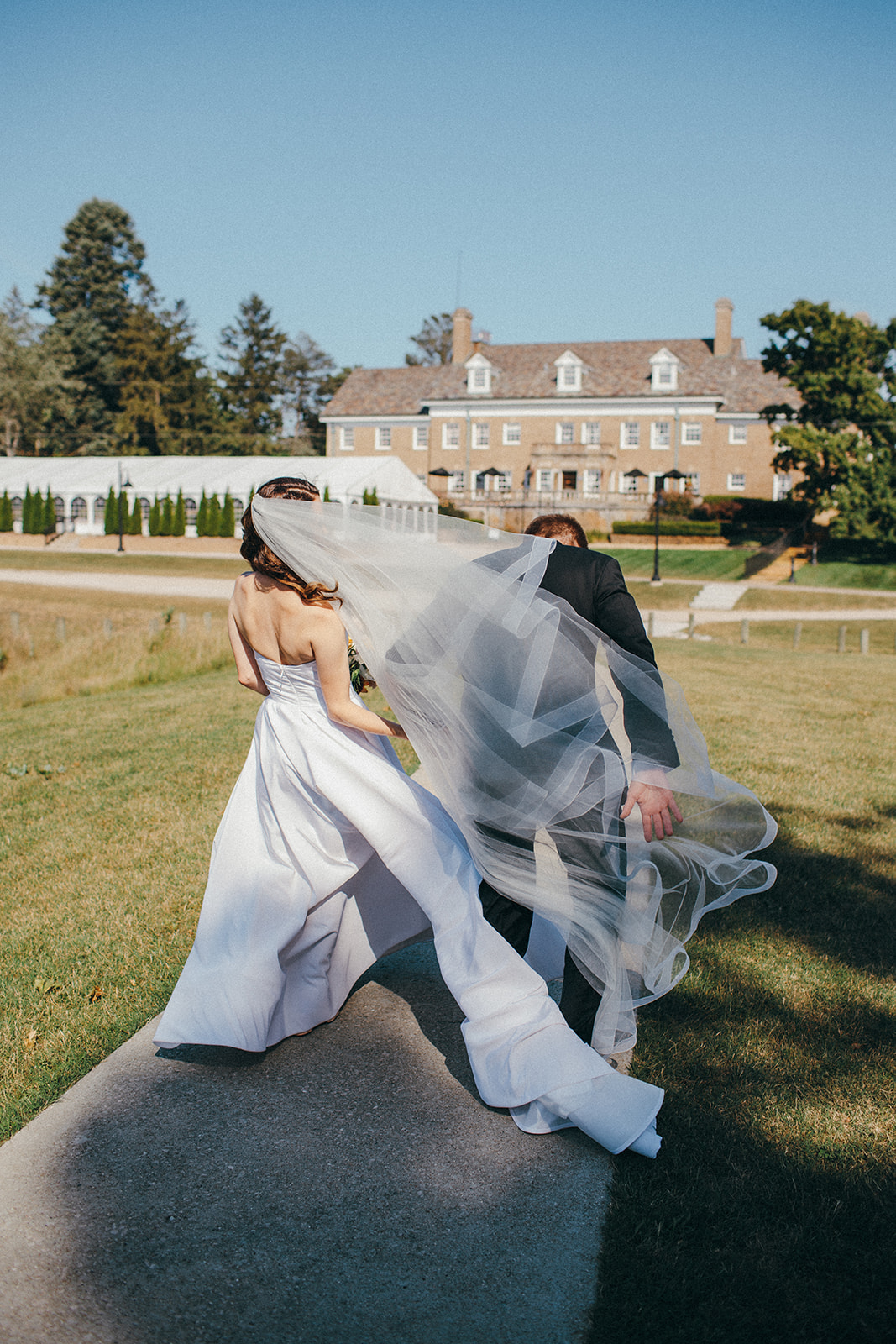 True documentary wedding photographs as a bride's Sarah Seven veil gets wrapped around her and the groom
