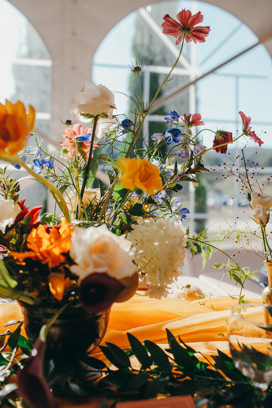 Orange, yellows, and poppy blue florals made this tented reception at the Felt Estate really come together 