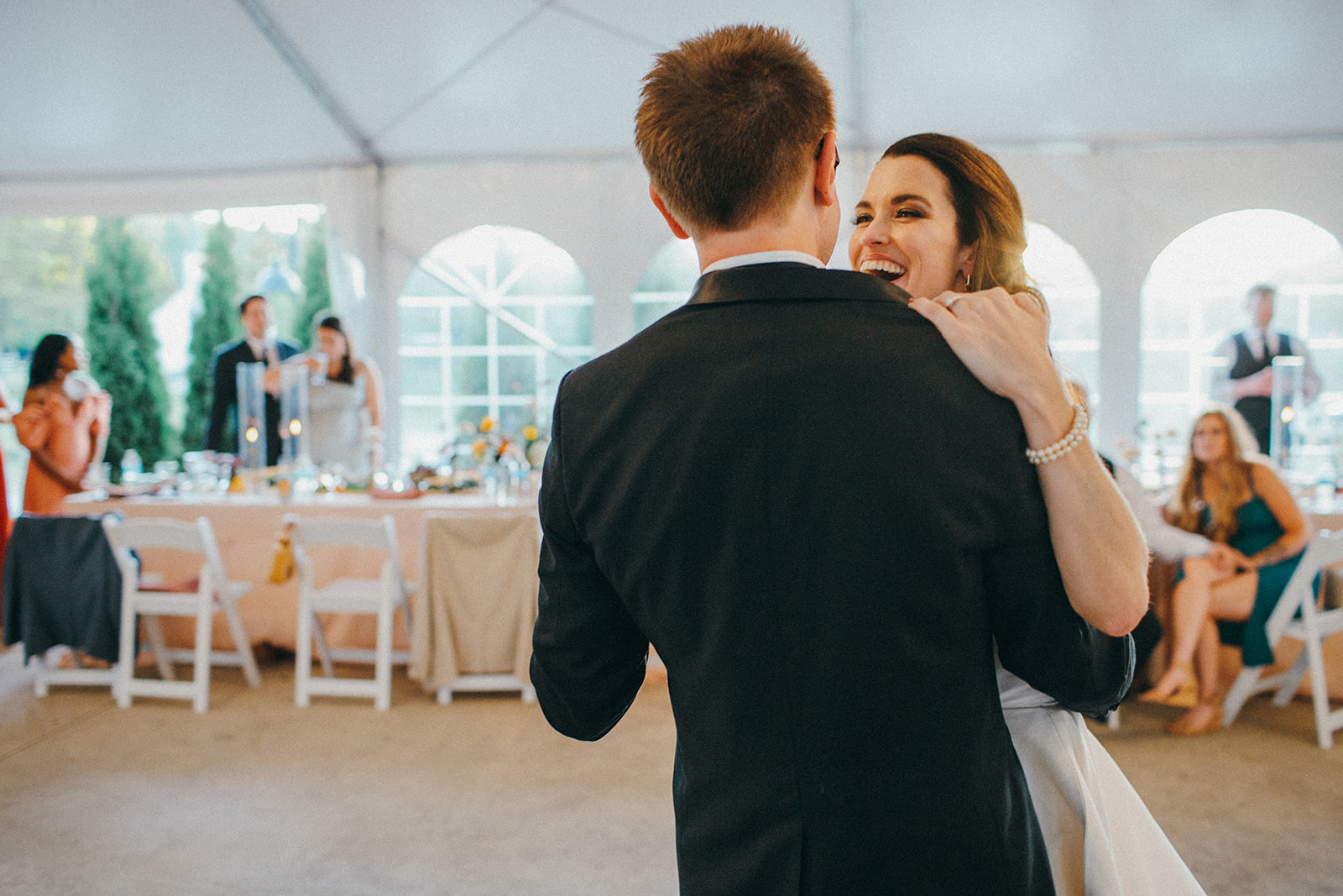 A bride and groom share their first dance under a tented reception at the Felt Mansion 