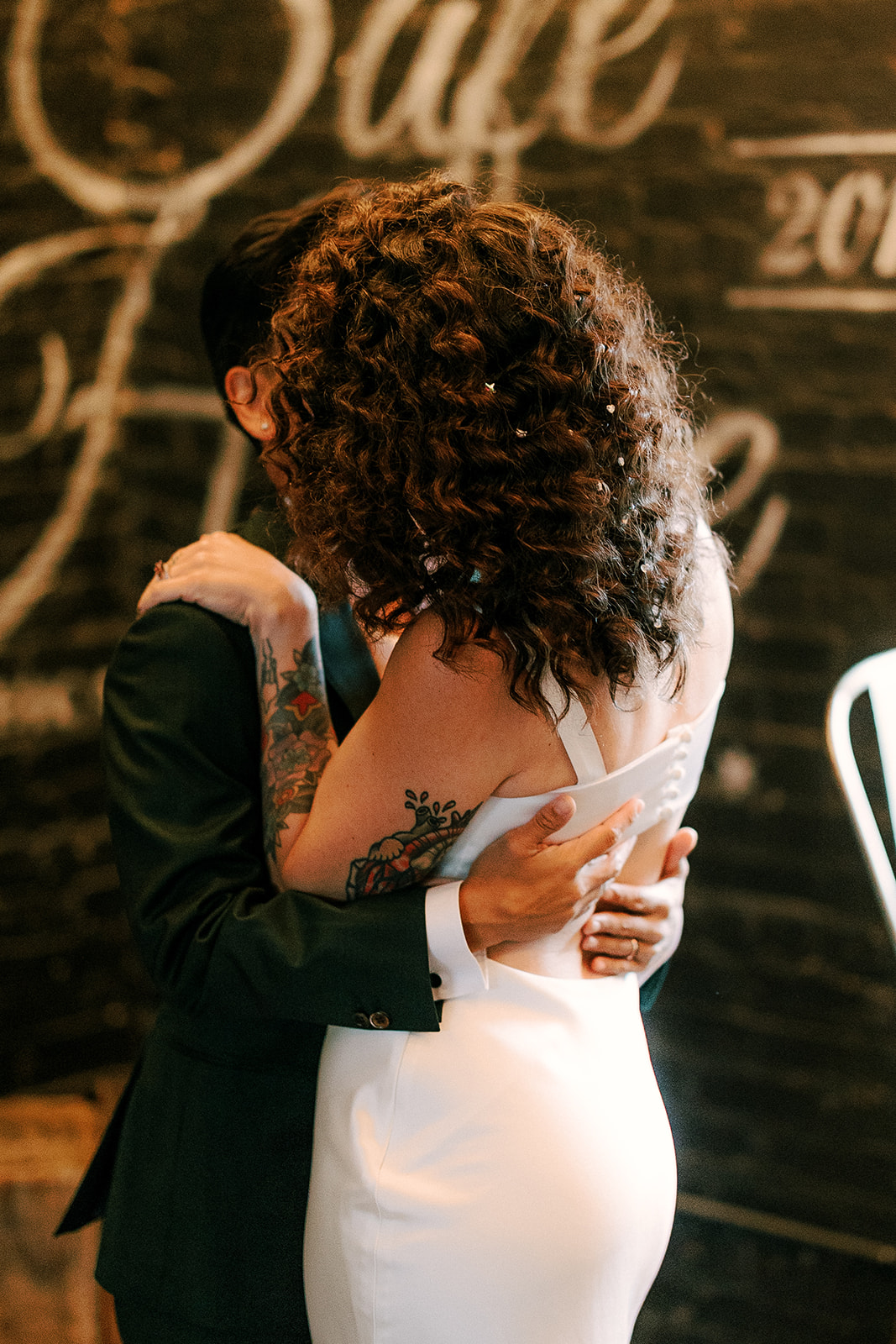 two brides embrace during their portraits at the joinery in chicago