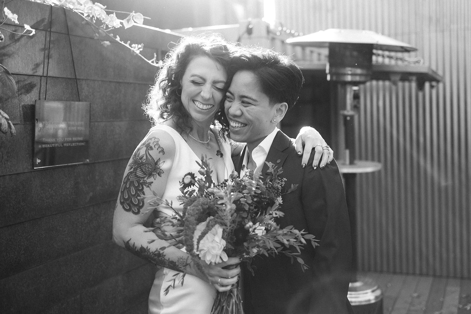 two brides embrace during their portraits at the joinery in chicago