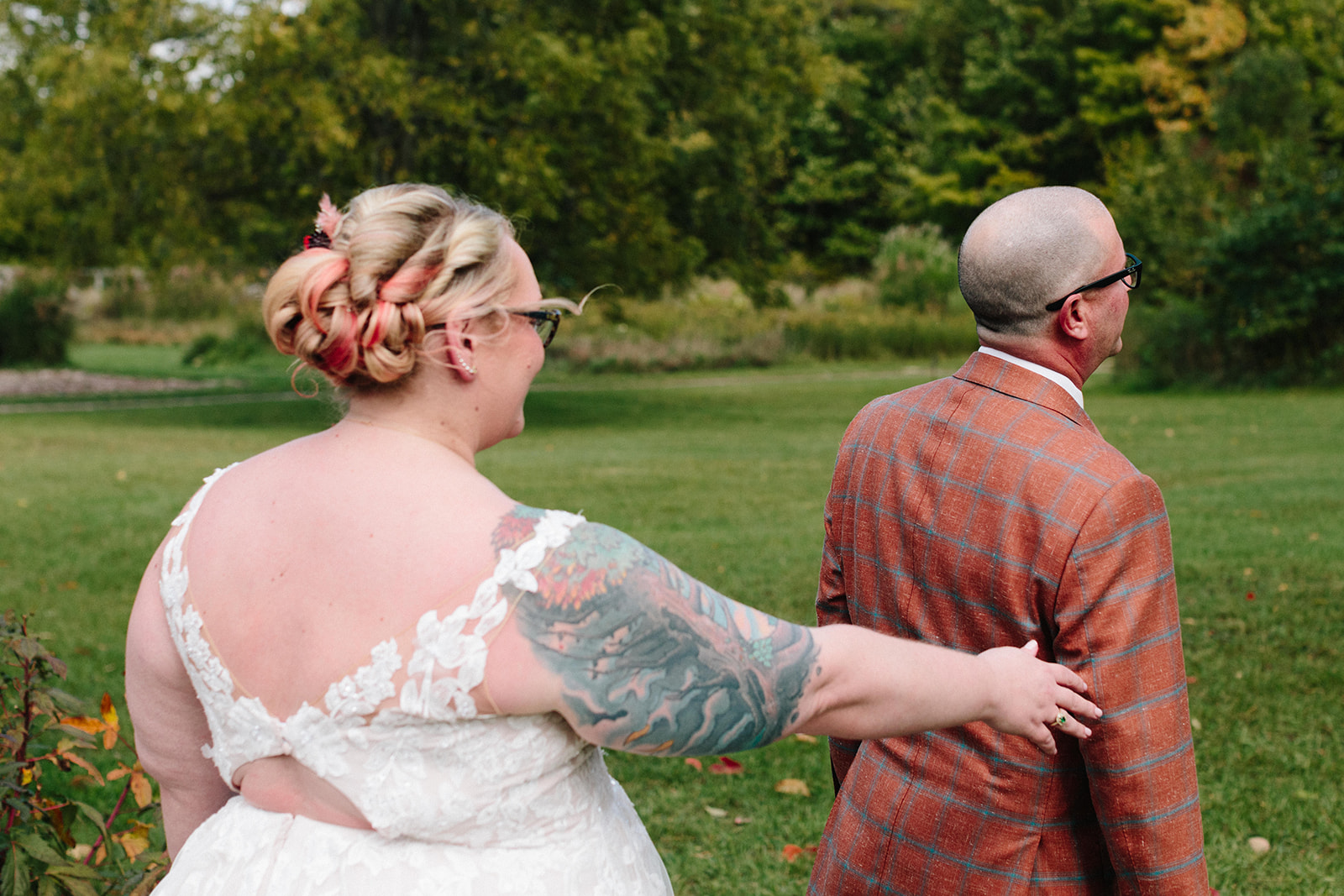 bride surprises a groom with a first look by grabbing his shoulder
