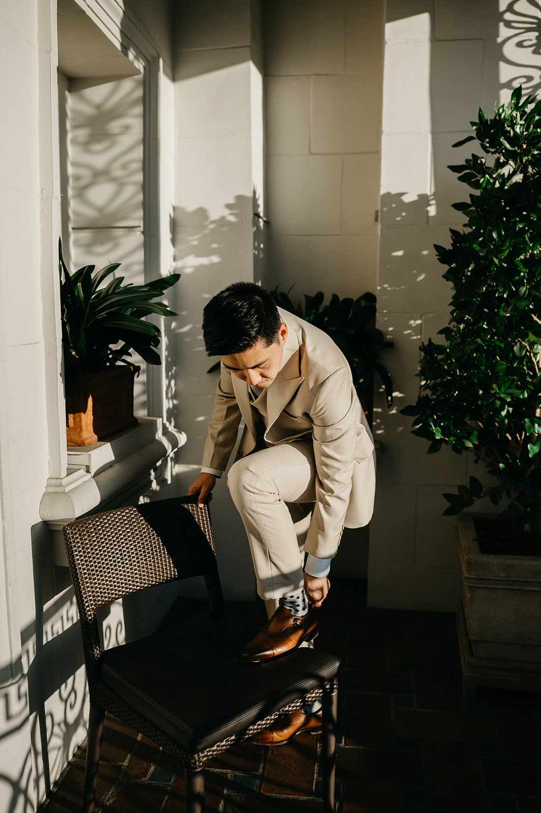 The groom putting on his shoes for his San Francisco wedding