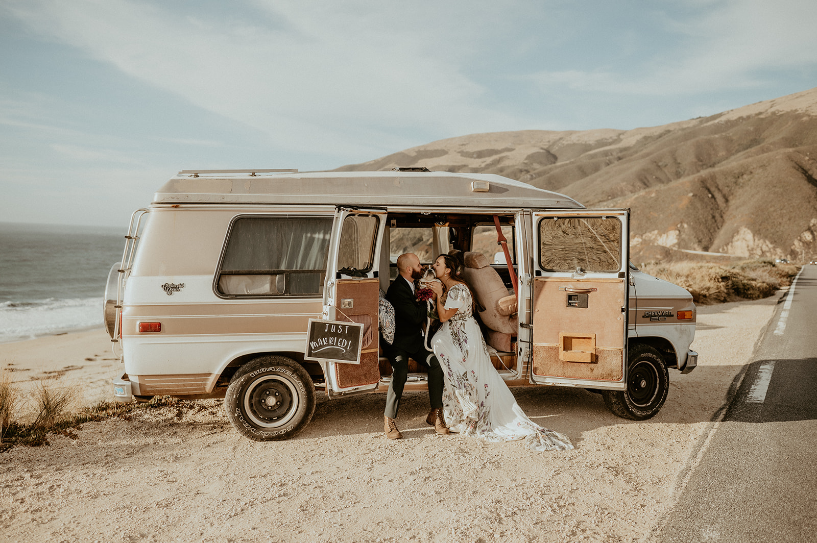 Bride and groom along the coast of Big Sur California with their bulldog and old camper van. 