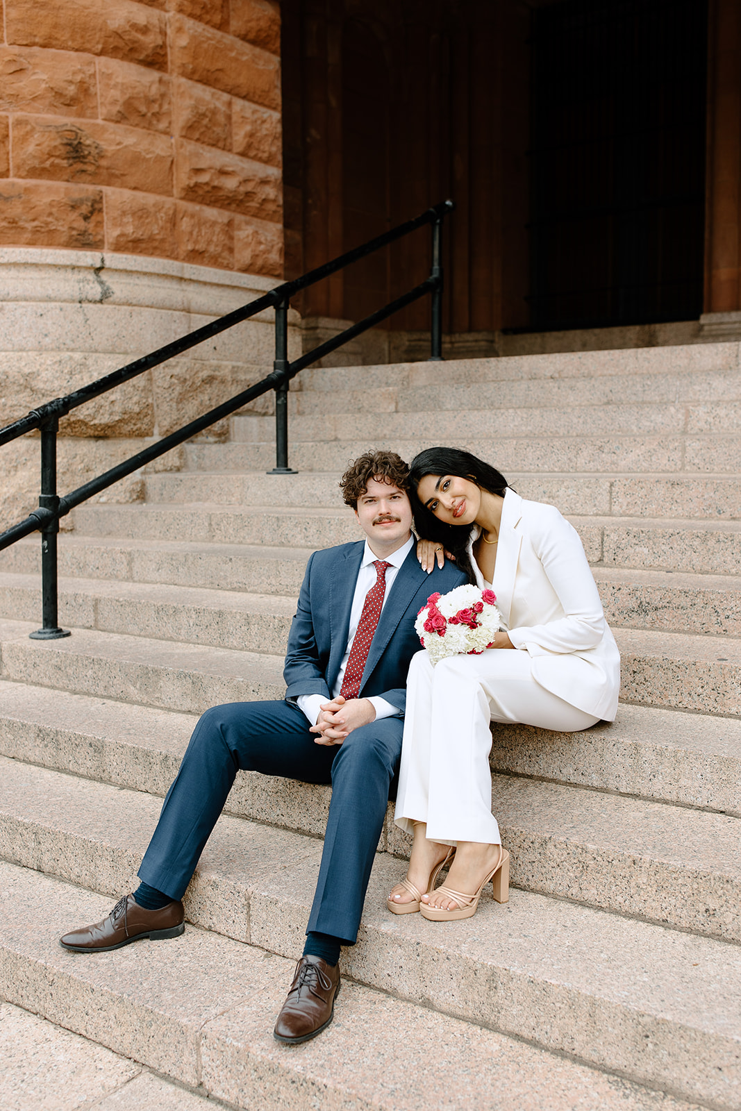 Bride and groom sitting on the courthouse steps