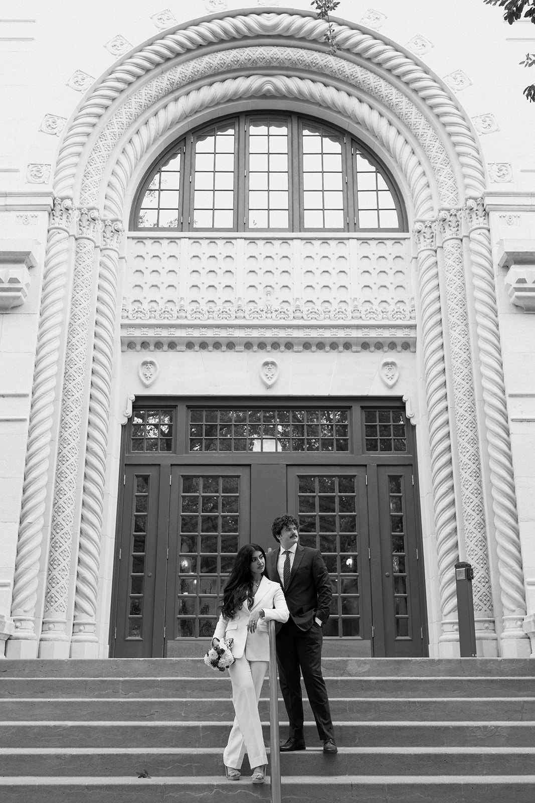 Bride and groom standing on city hall steps