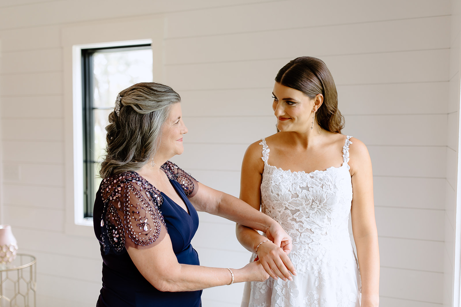 Mother of the bride putting a bracelet on her daughter