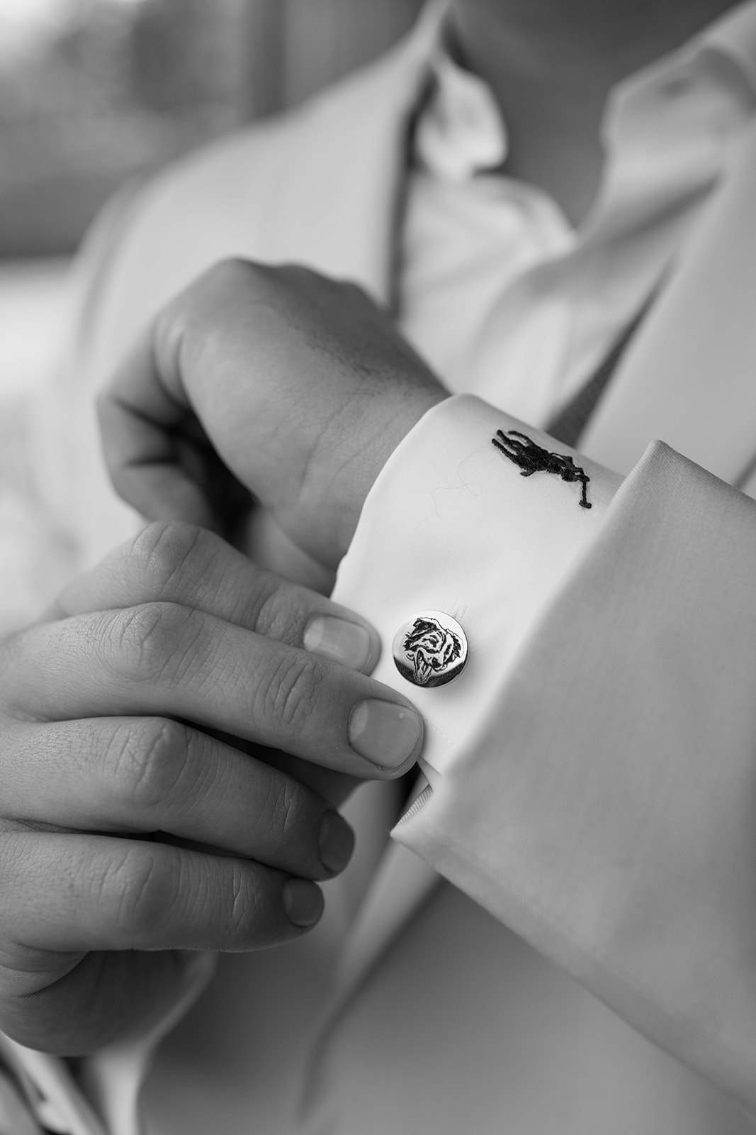 Groom adjusting his cuff links and watch