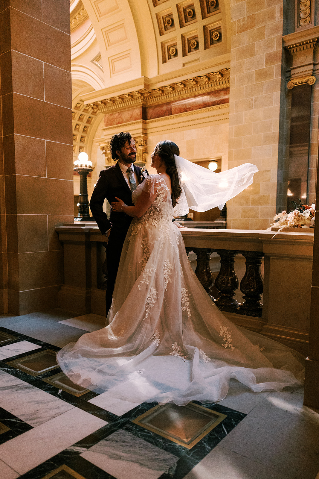 bride and groom get close during portraits at the wisconsin state capitol during their fall elopement in madison