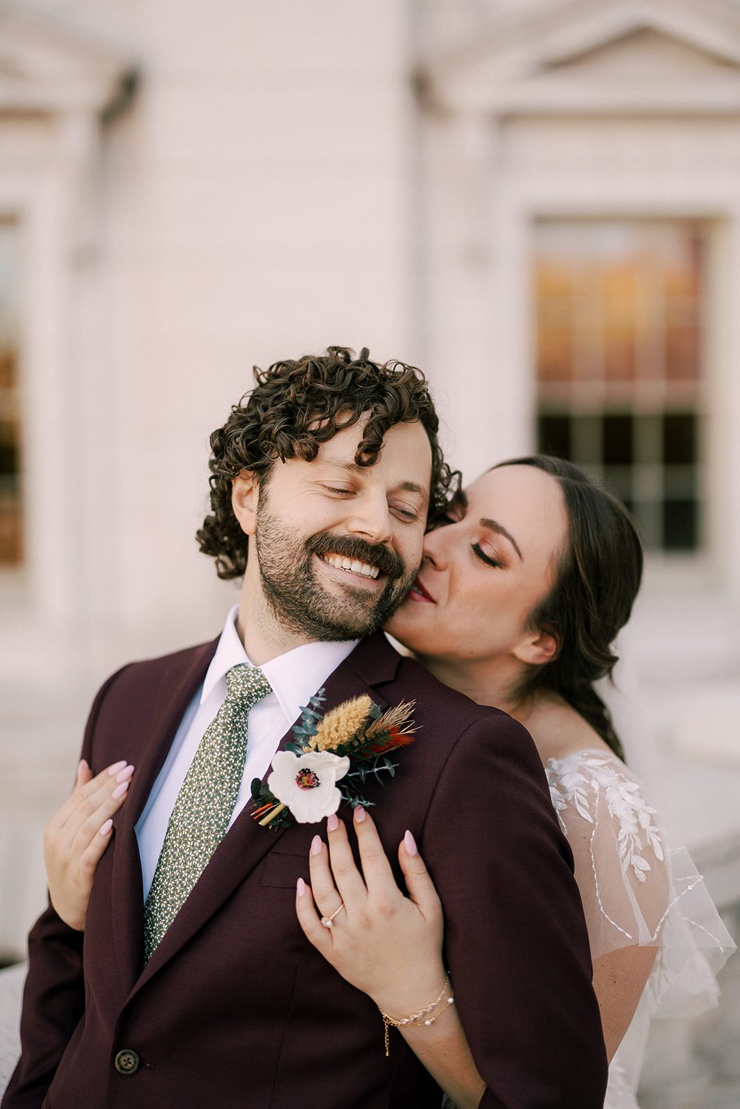 bride holds her groom at the wisconsin state capitol during their fall elopement in madison