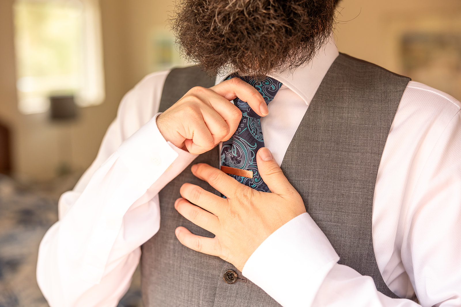 groom puts tie on