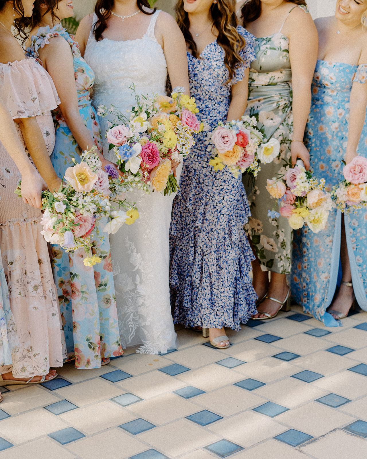Bridesmaids in floral dresses holding floral bouquets by West and Rock Designs