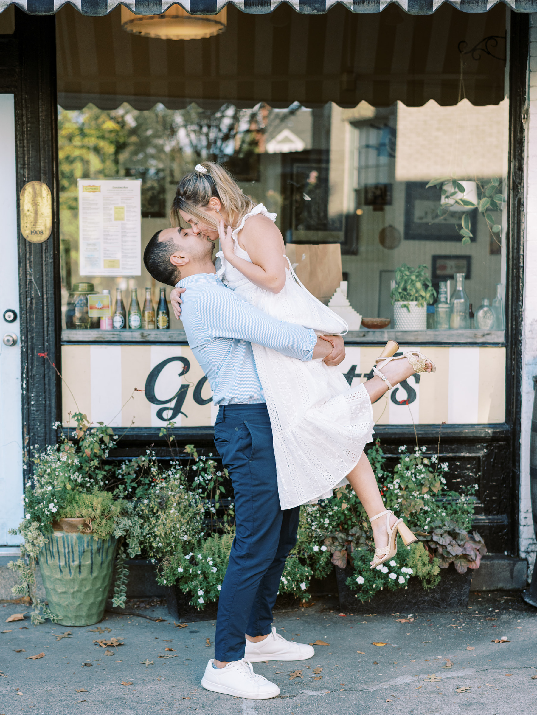 A couple's engagement photo kissing in front of Garnetts Sandwich Shop in Richmond Virginia