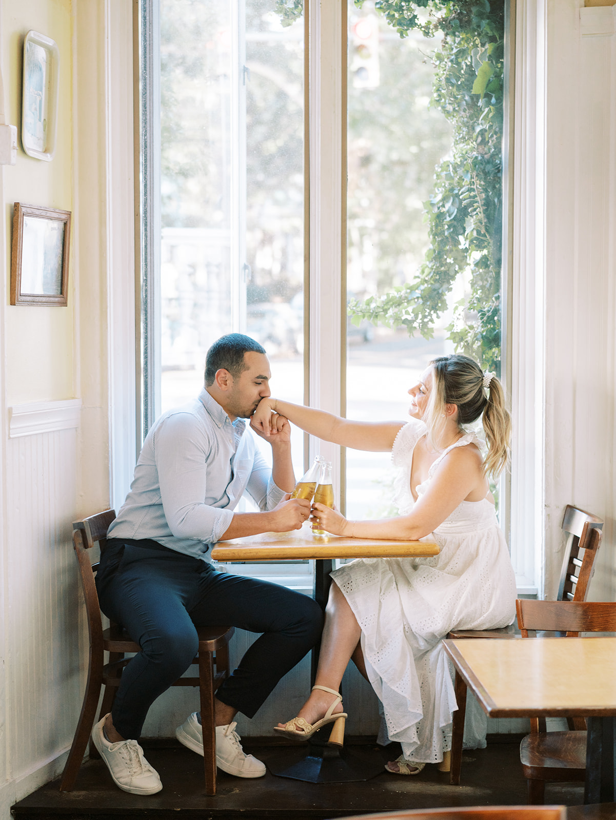 a couple inside of garnetts sandwich shop with tall windows behind them