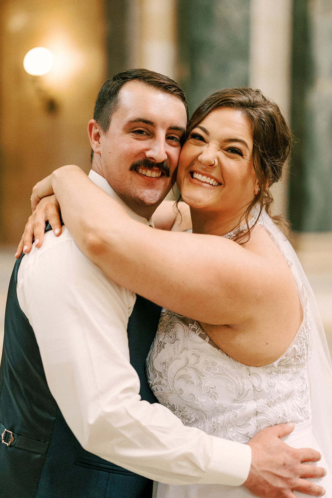 bride and groom embrace in capitol building during their intimate elopement day