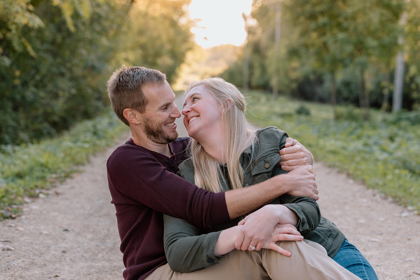 Couple sits snuggled together Twin Cities engagement photos