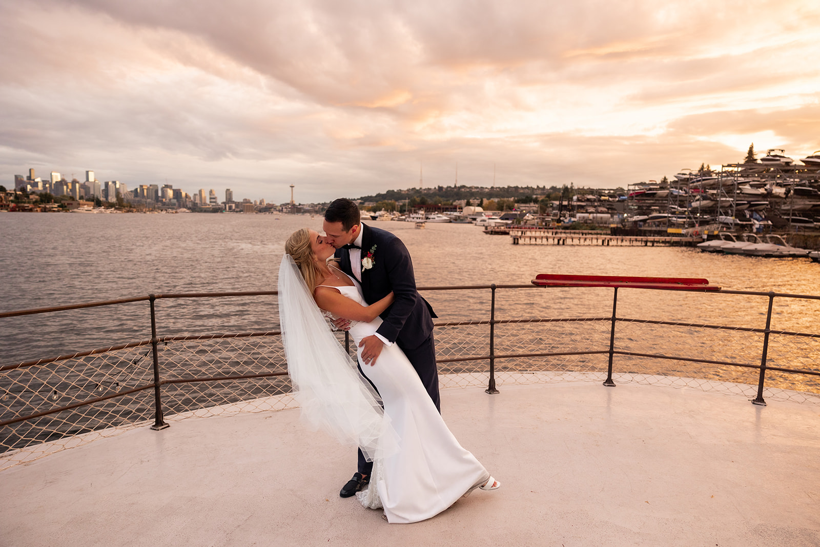 A couple married at the MV Skansonia kissing at sunset on the waterfront in Seattle 