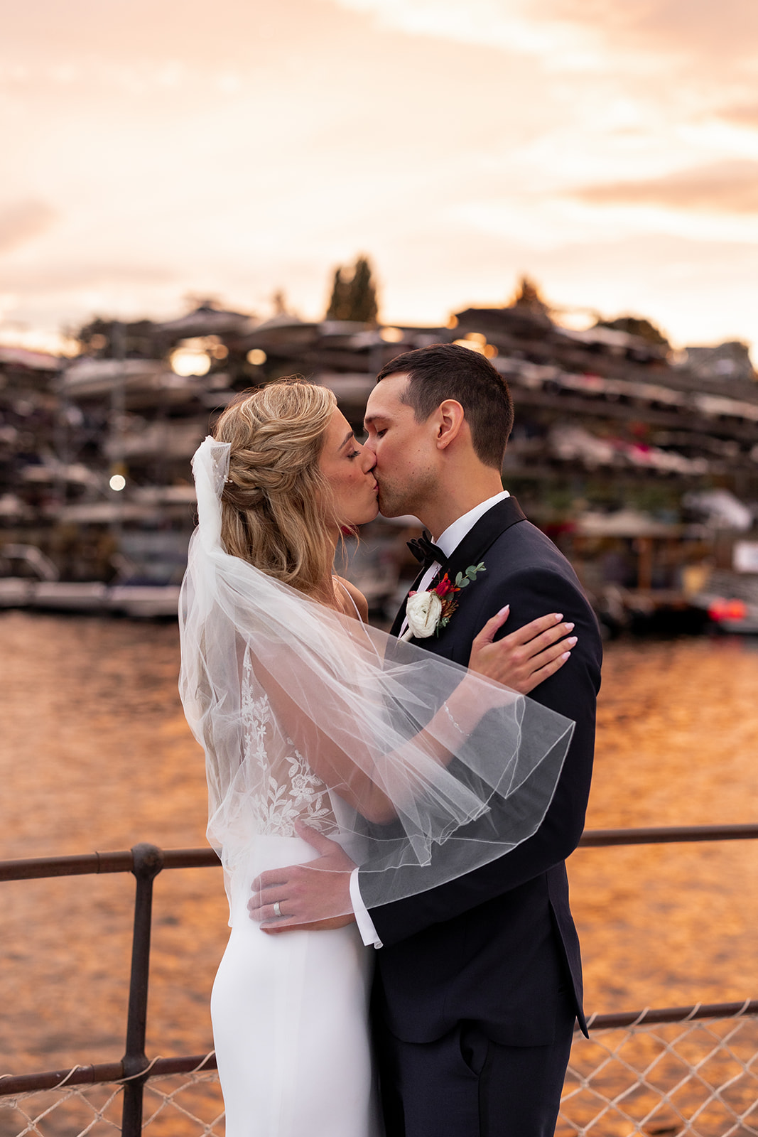 A couple married at the MV Skansonia kissing at sunset on the waterfront in Seattle 