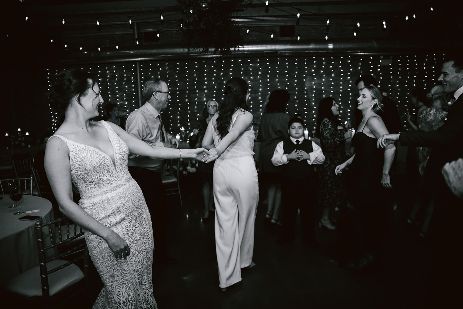 Guests joining the two brides on the dance floor, creating a lively and joyous atmosphere at Loft on Lake.