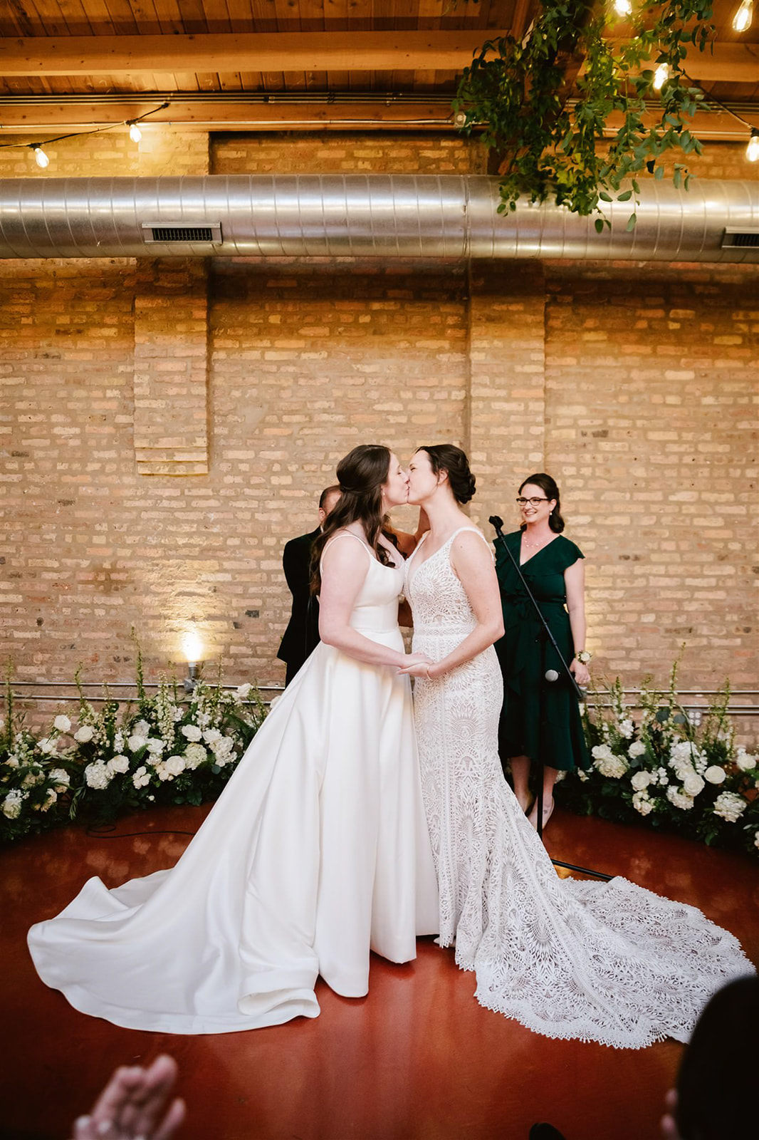 Two brides share their first kiss as a married couple at Loft on Lake, a heartwarming moment filled with love and joy.