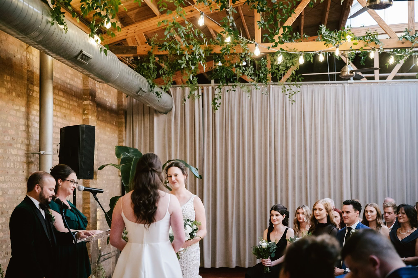 Two brides at their ceremony, sharing heartfelt moments and celebrating their love at Loft on Lake.