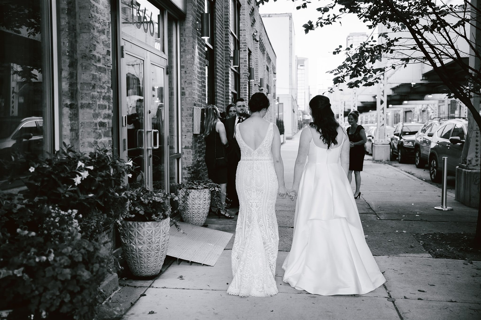 Two brides walking towards Loft on Lake, their love and anticipation evident as they head to their wedding celebration.