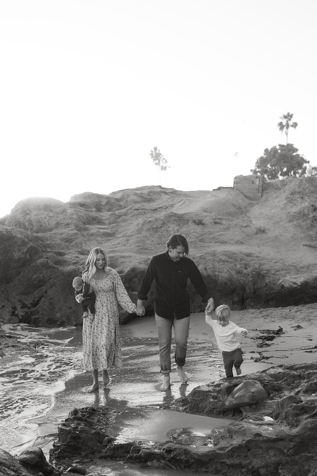 golden hour family laguna beach photoshoot california socal children playing in water parents hugging children maternity