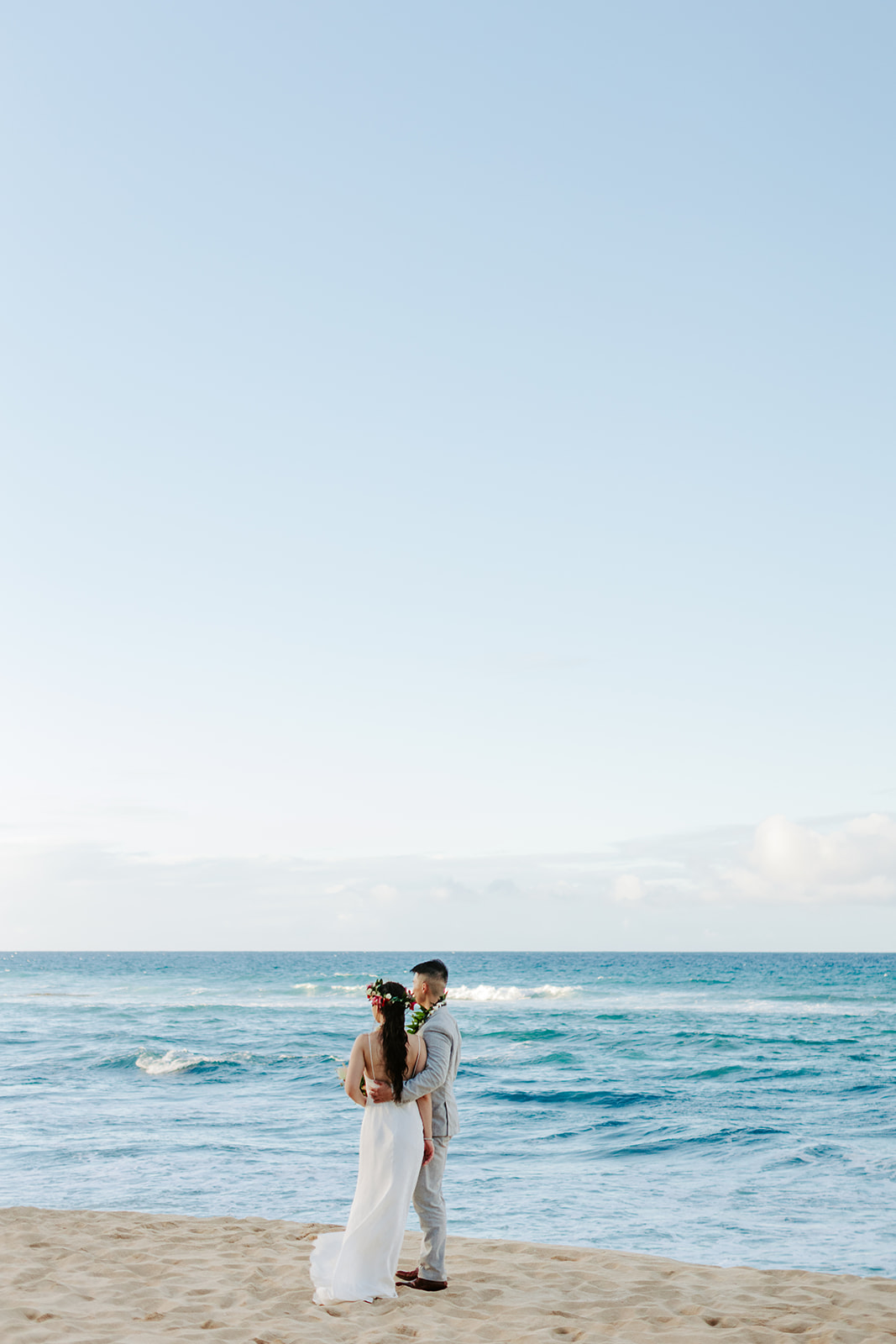 A couple who eloped on the North Shore of Oahu explore the beach after getting married in Hawaii. 
