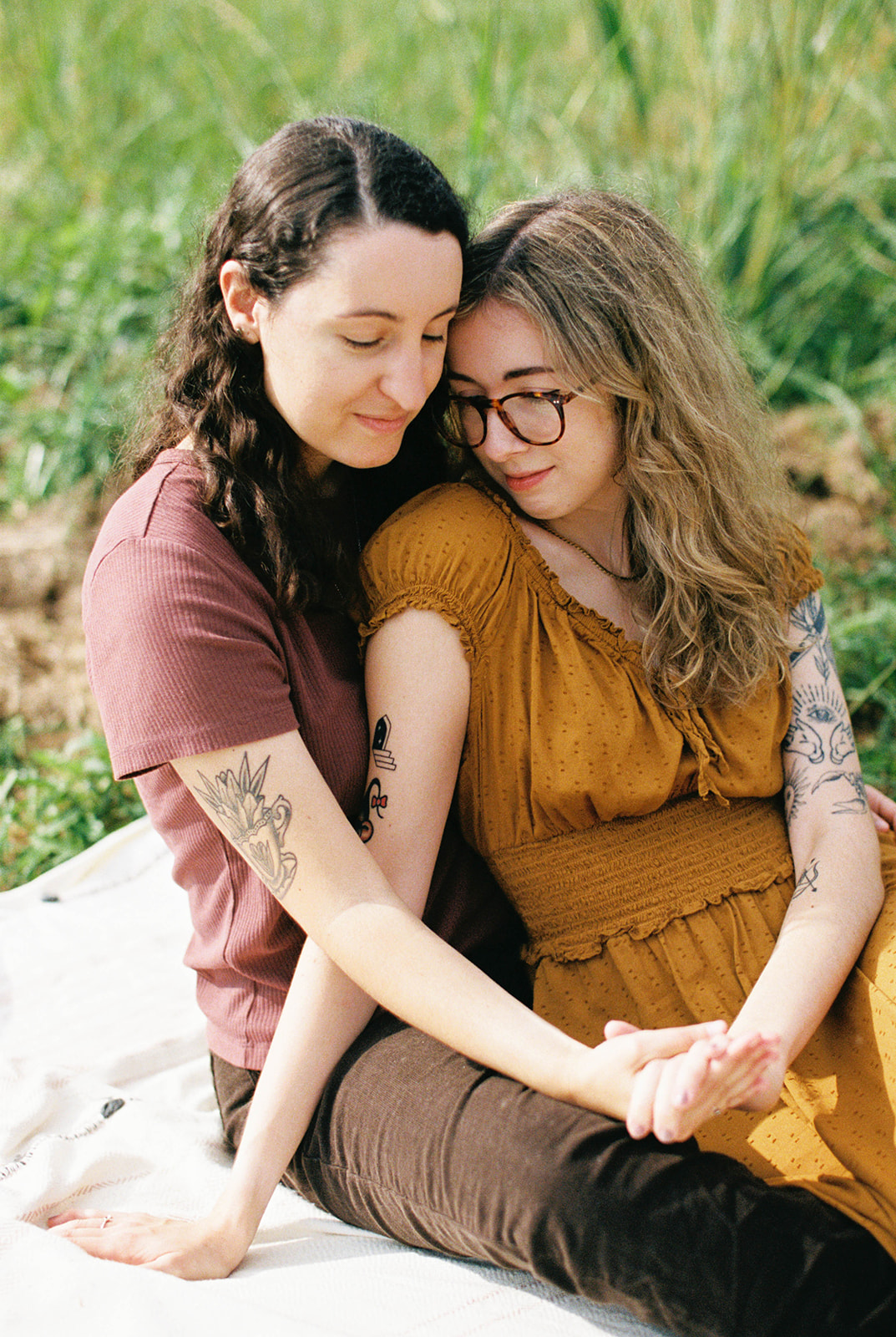 LGBTQ+ couple cuddling and looking at engagement ring during their engagement session in Atlanta, Georgia