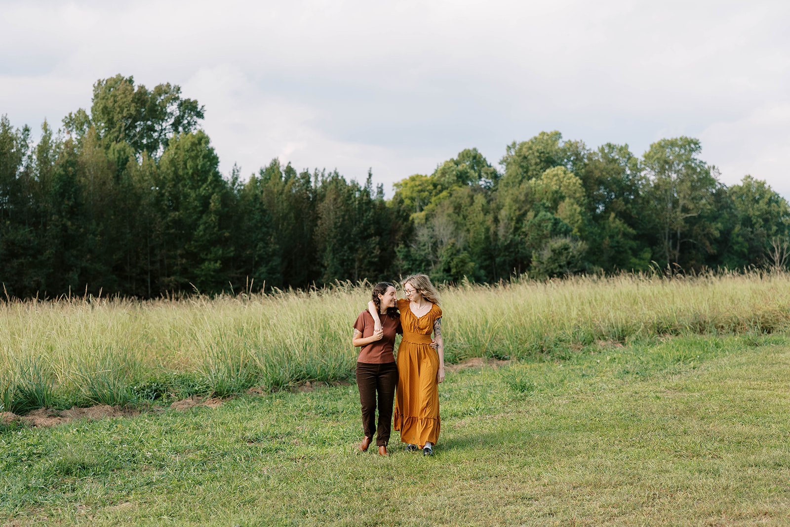 LGBTQ+ couple with their arms around each other walking during their engagement session in Atlanta, Georgia