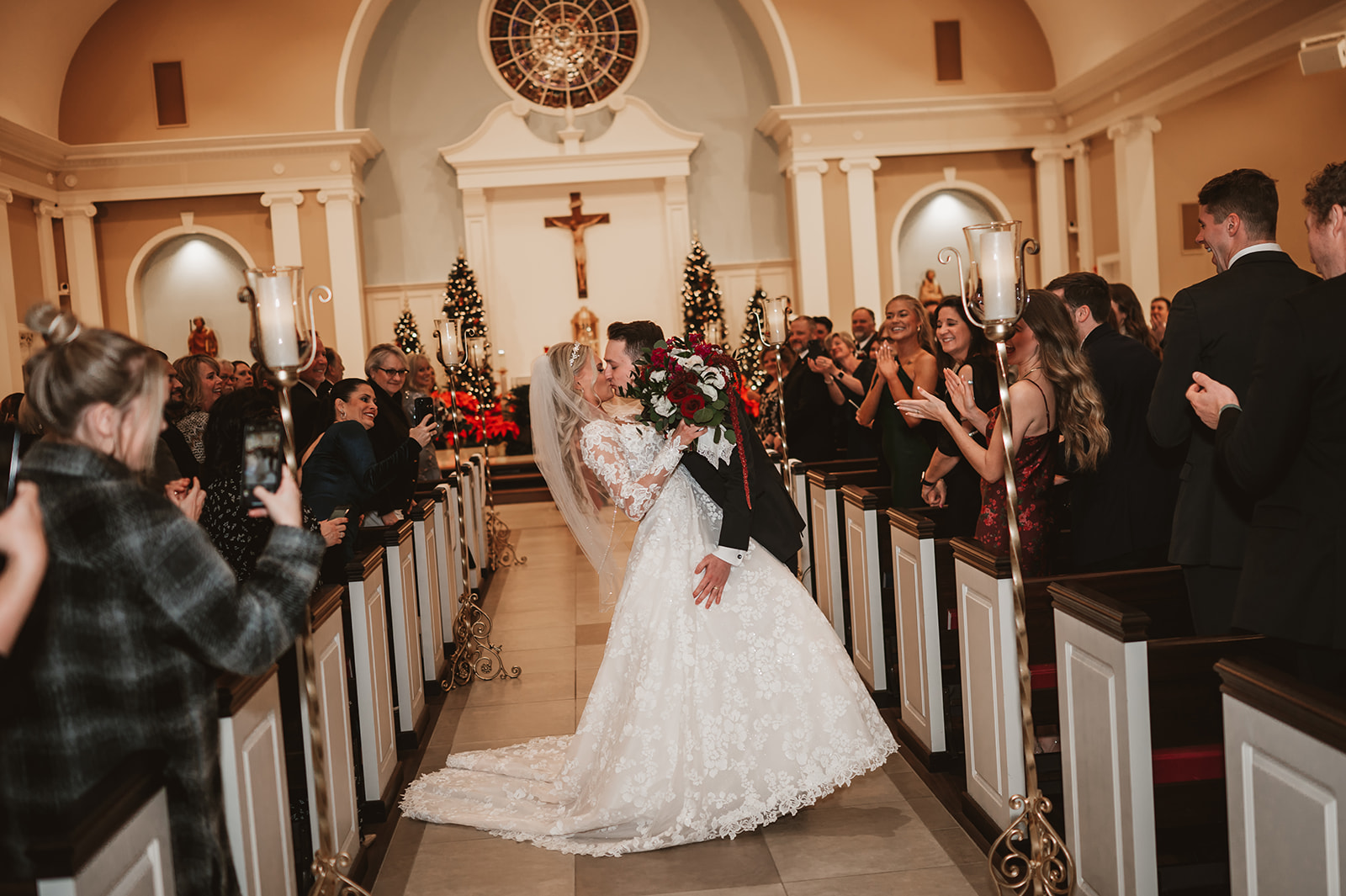 Chevy Chase Country Club Wedding Photo - ceremony in St James Catholic Church mid aisle kiss