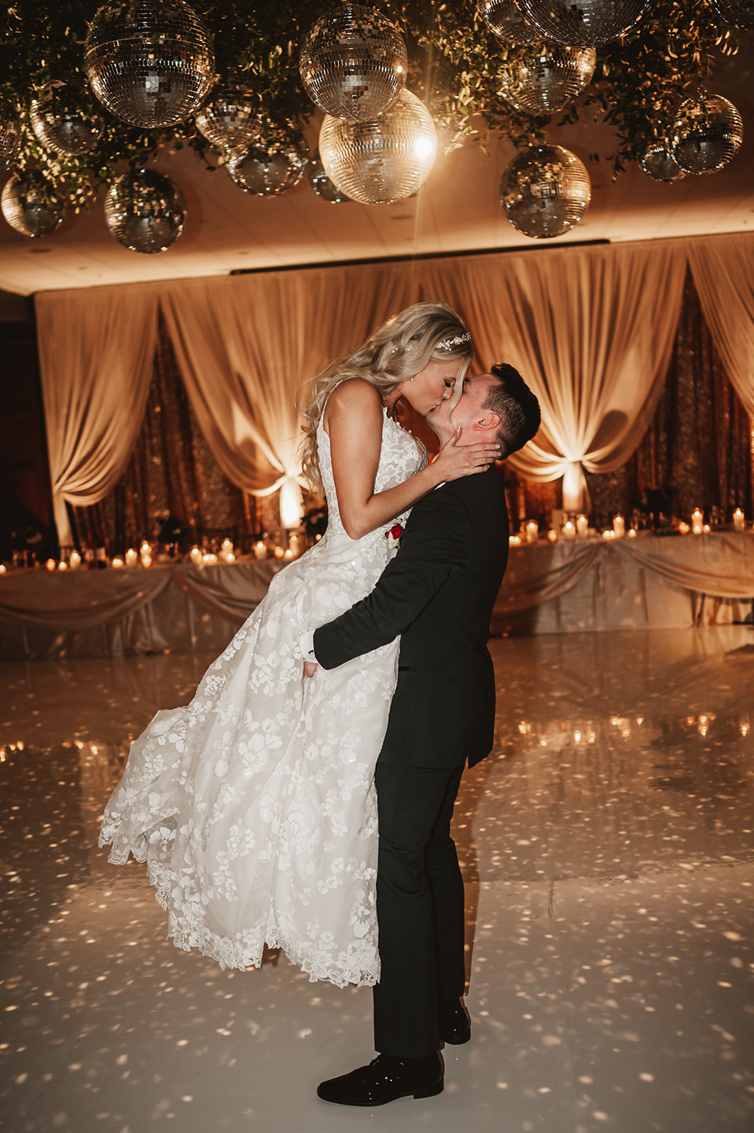 Chevy Chase Country Club Wedding Photo - groom kissing bride picked up dance floor