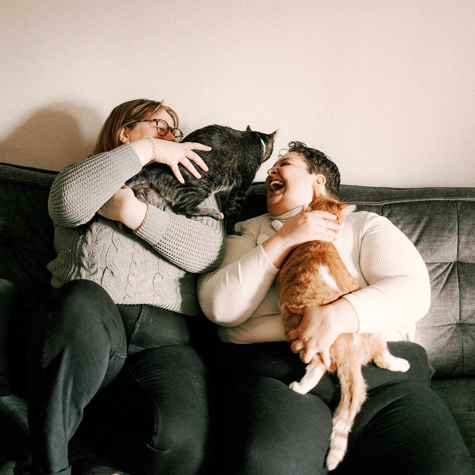 lgbtq couple laughs at their home with their cats
