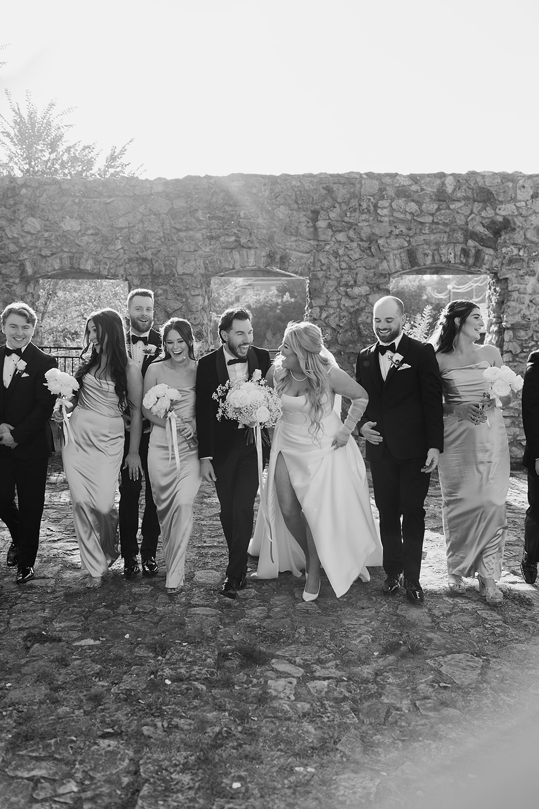 bridal party posing by the riverside at Cambridge Mill, surrounded by the picturesque fall foliage and the scenic beauty