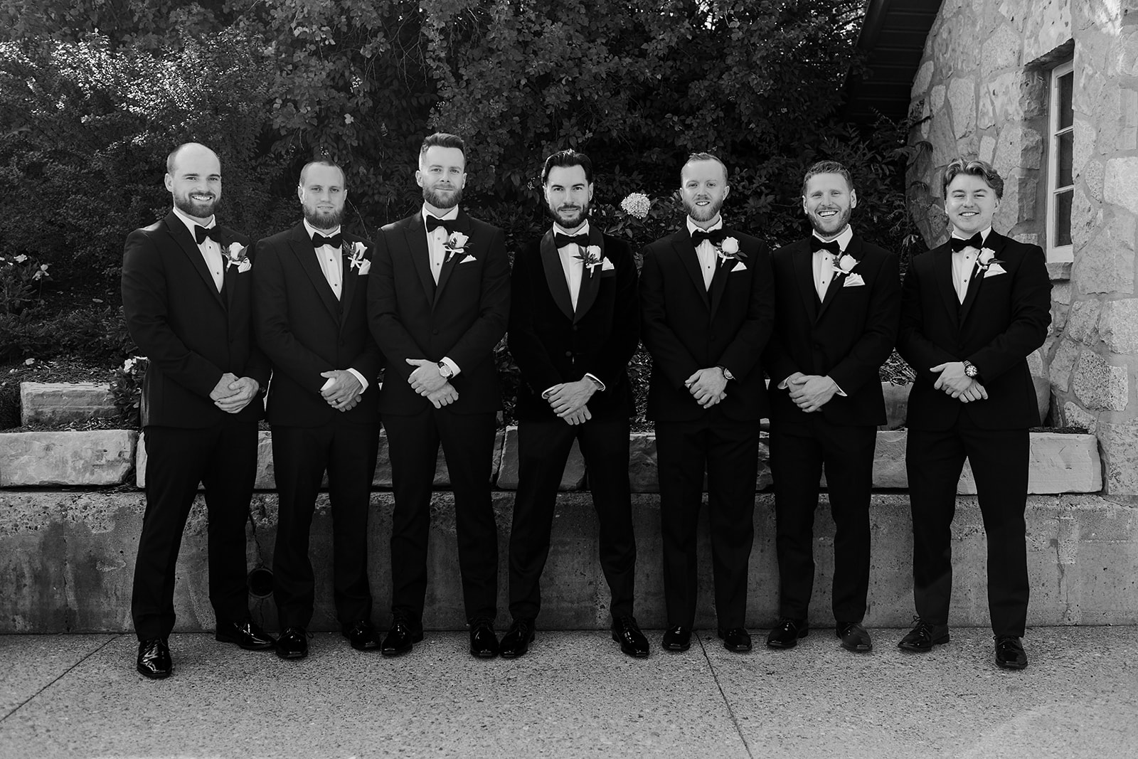 Brandon's groomsmen looking dapper in suits against the autumn backdrop of Cambridge Mill, embodying rustic charm