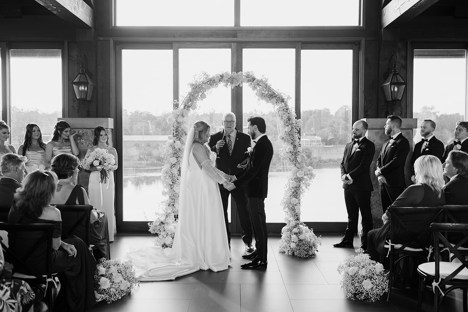 Corie and Brandon exchanging vows by the riverside at Cambridge Mill during their enchanting fall wedding ceremony