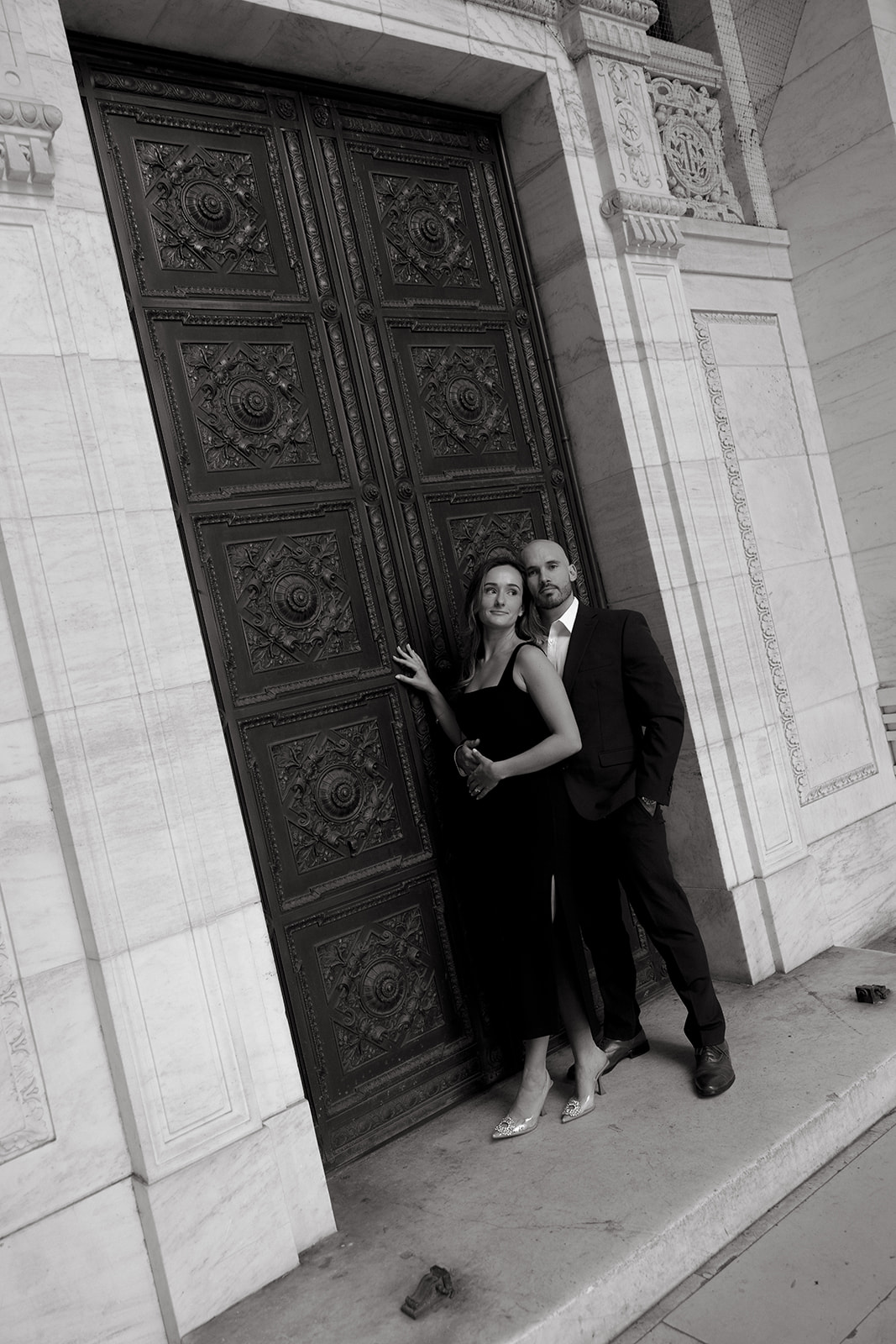 A couple hangs out for their engagement session at the New York Public Library