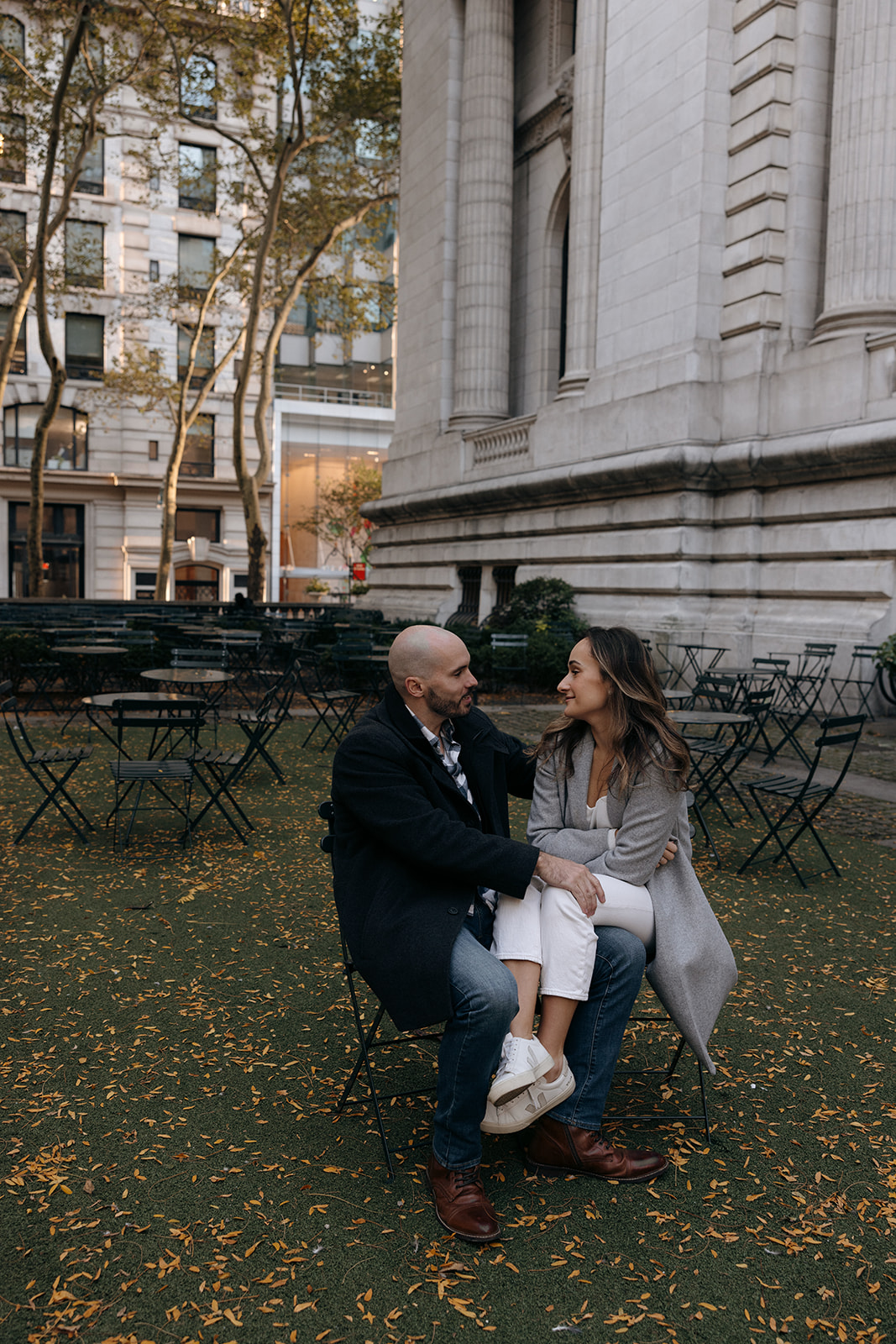 A couple sits together outside of the New York Public Library park