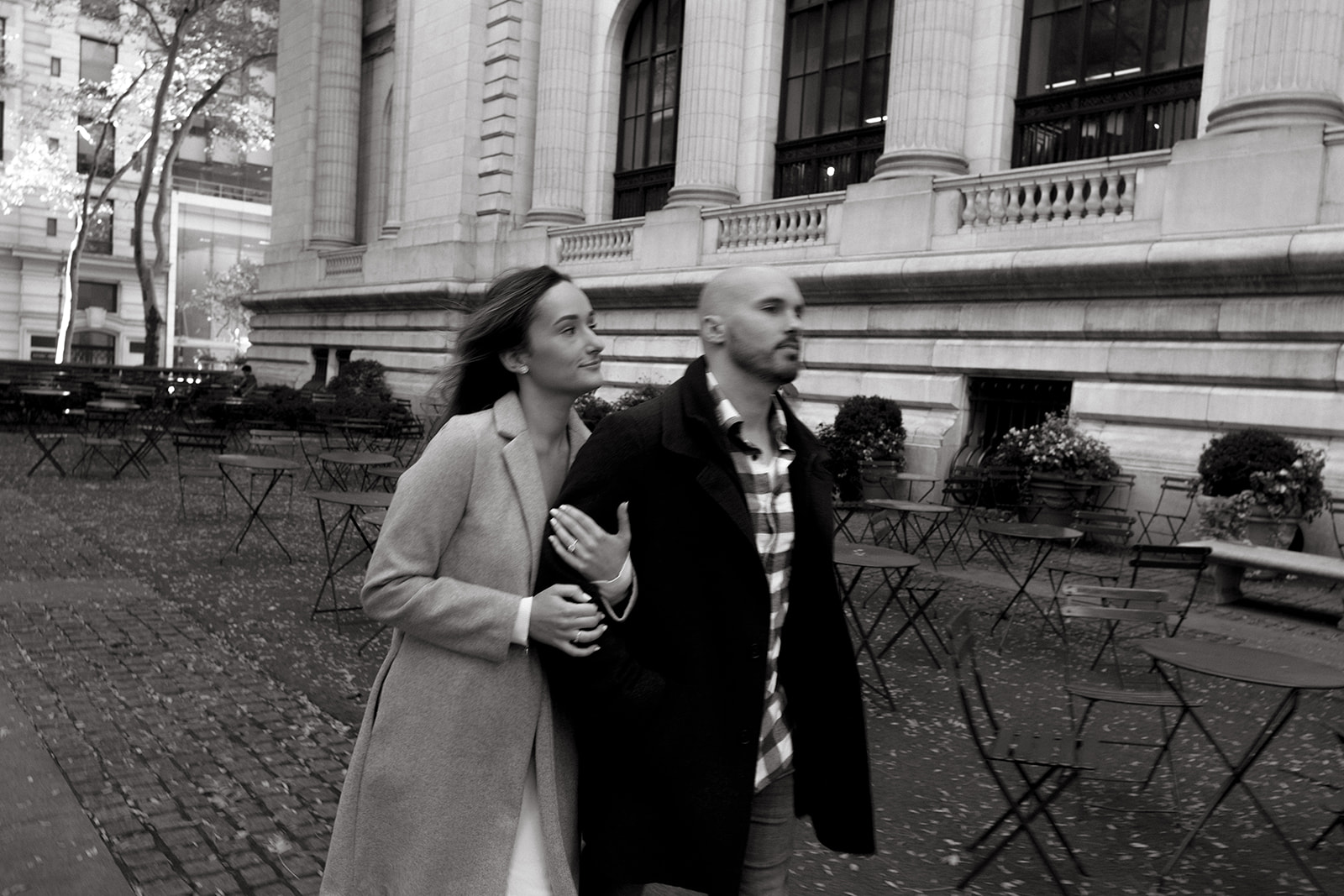 A couple walks together outside of the New York Public Library park