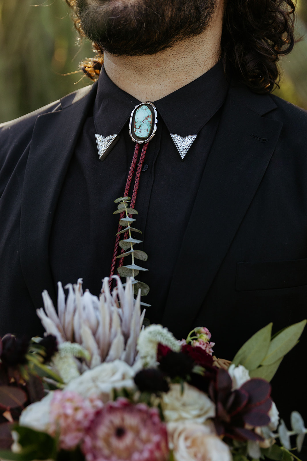 alternative western grooms style bolo tie and bouquet of flowers 