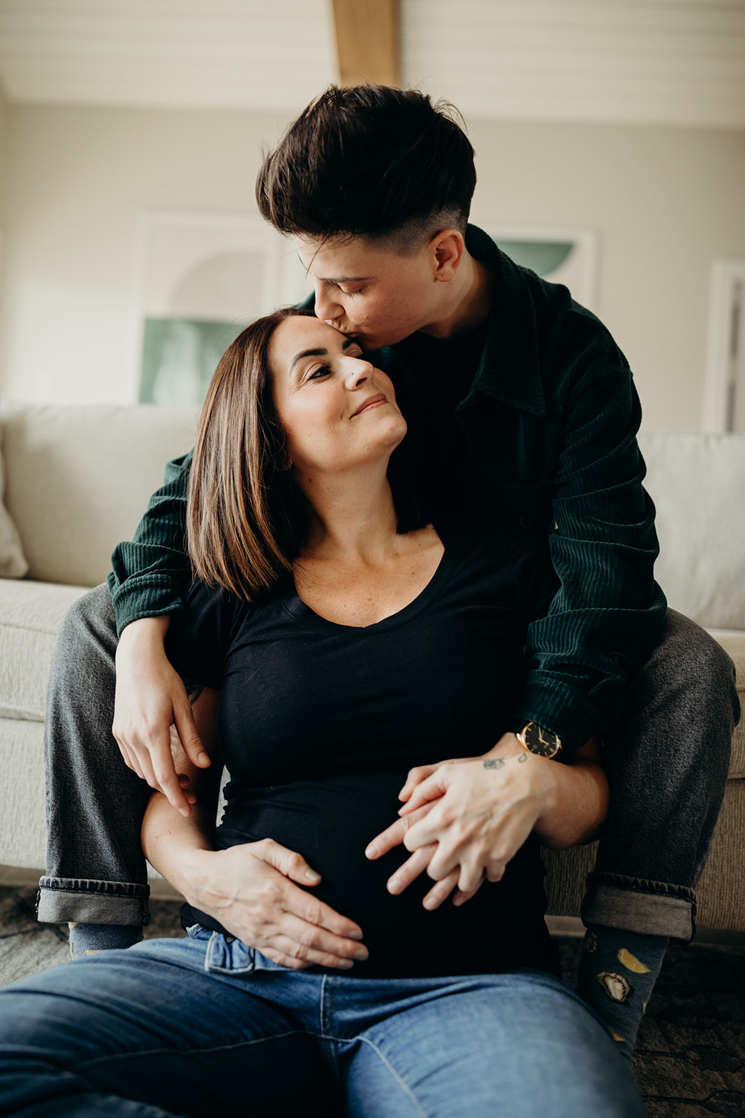 Couple looks lovingly at each other during their at-home maternity photoshoot