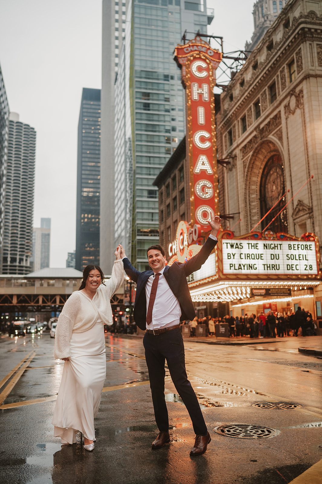 Intimate rainy day Chicago elopement wedding photography - in front of Chicago theatre sign