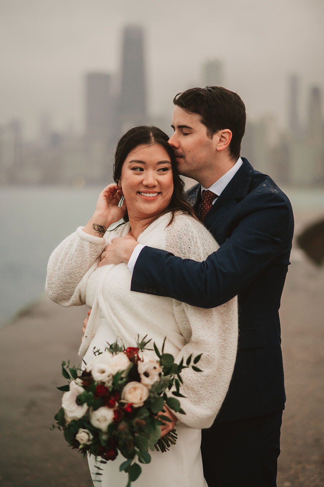 Intimate rainy day Chicago elopement wedding photography - Skyline over lake Michigan, couple cuddling