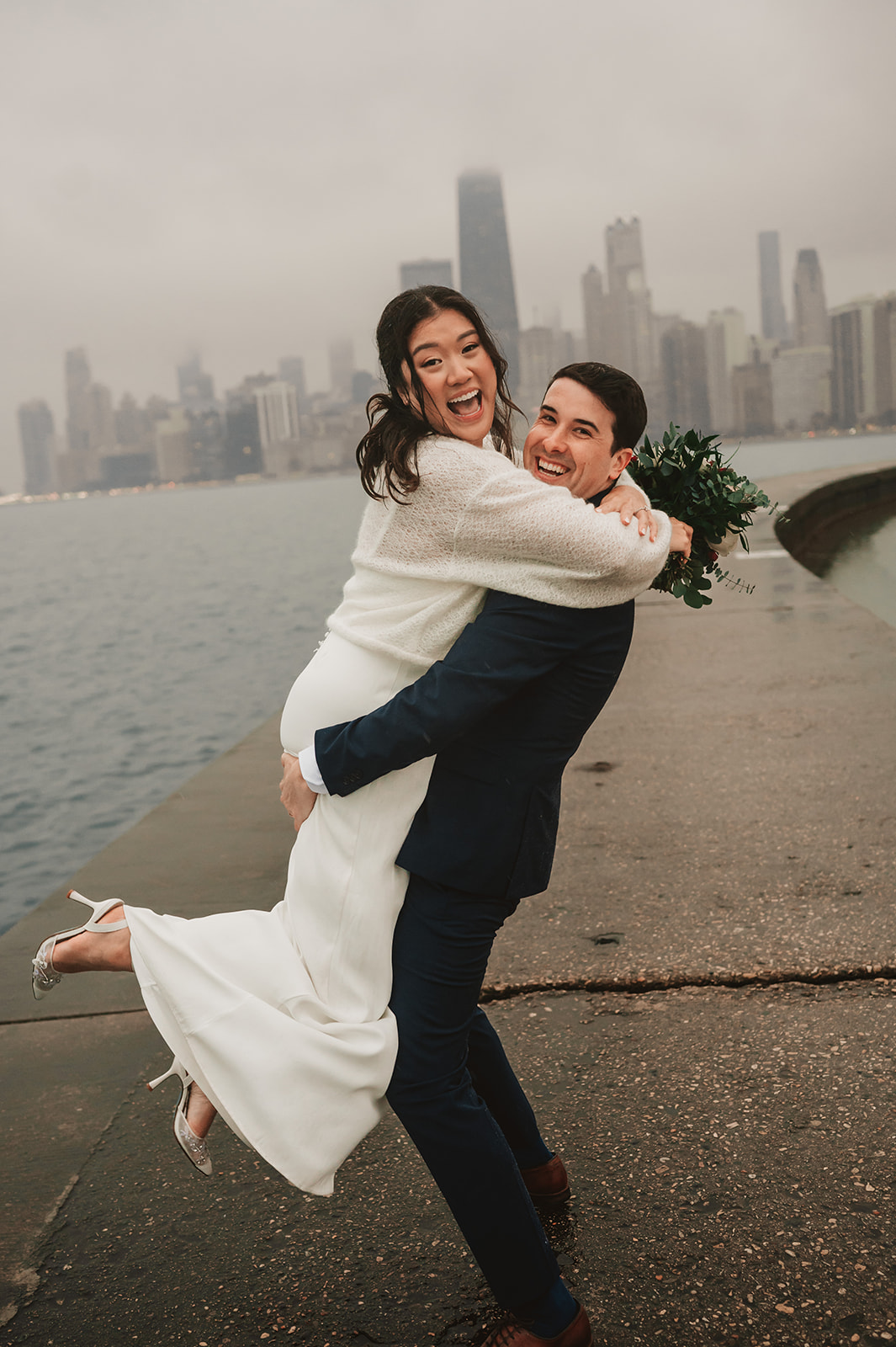 Intimate rainy day Chicago elopement wedding photography - Skyline over lake Michigan, couple cuddling