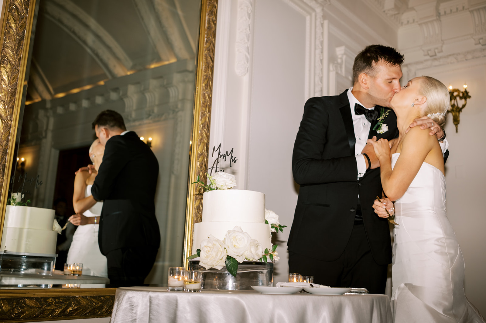 Bride and groom kiss after cutting wedding cake at DAR in Washington DC wedding
