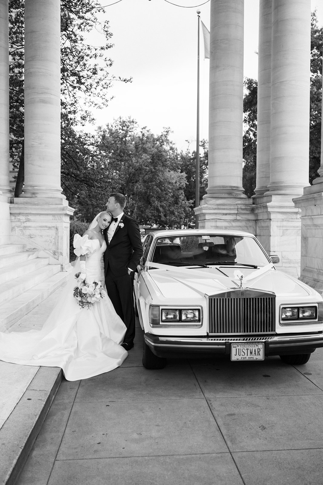 Bride and groom have a moment next to classic Rolls Royce at DC wedding