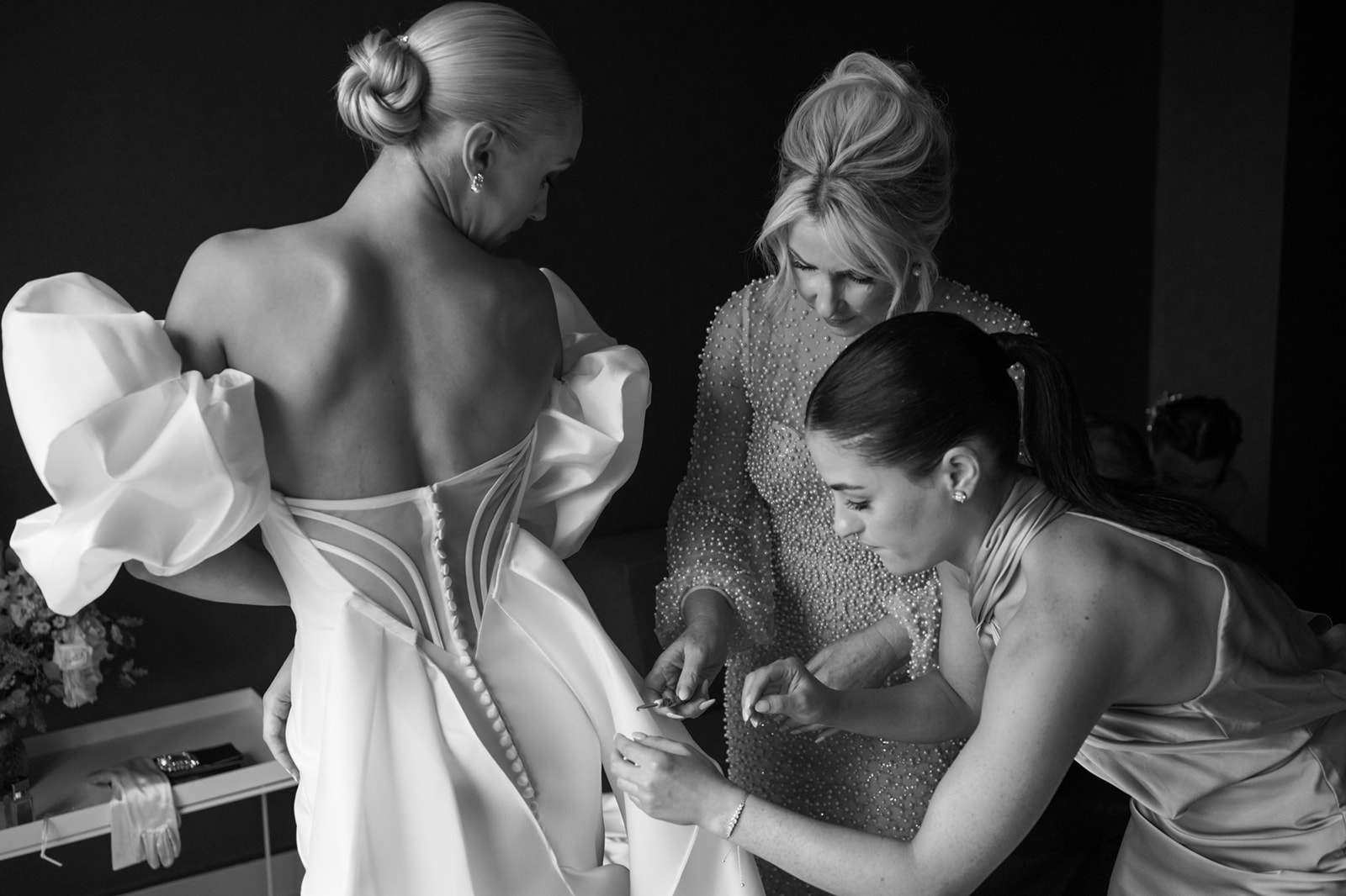 Bride's mother and sister help her get into wedding dress at Hotel Washington