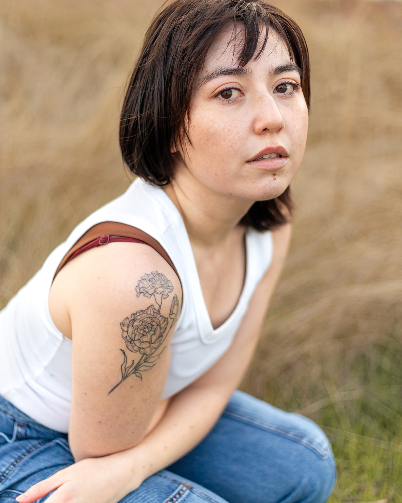 nonbinary person portrait showing off tattoo