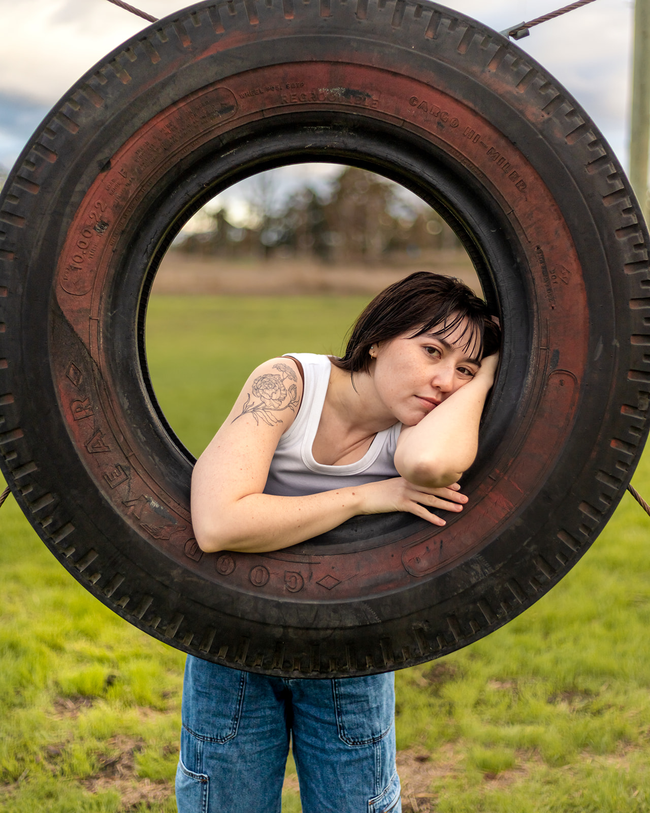 trans person leans on tire