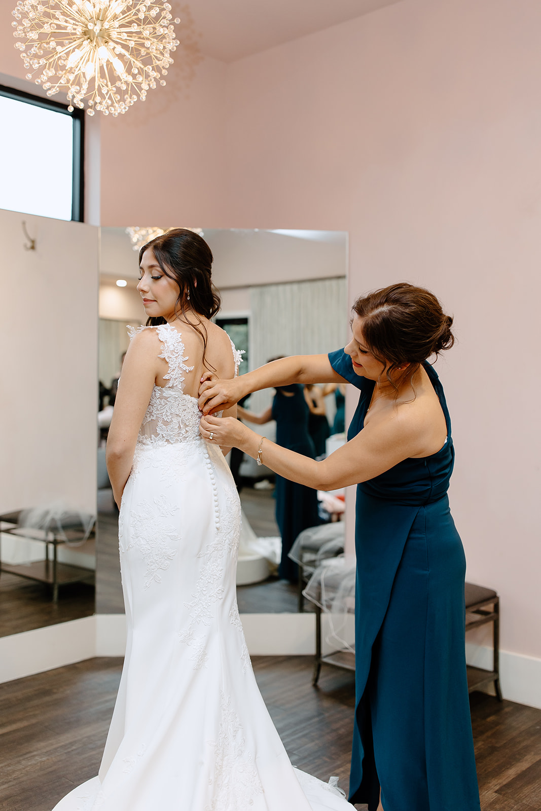 Mother of the bride zipping her daughter's dress